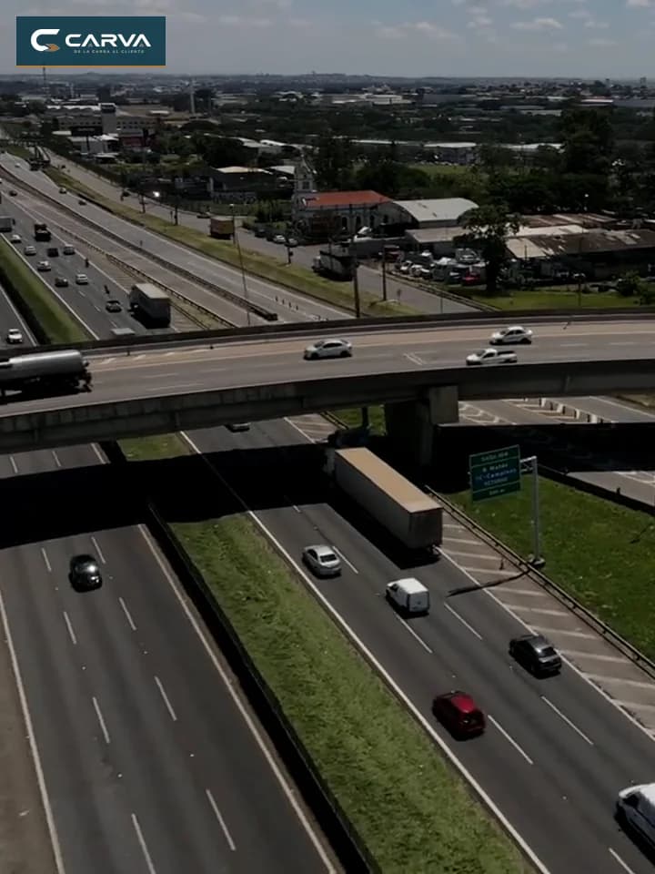 Tráfico de carga avanzando por un distribuidor vial visto desde un dron